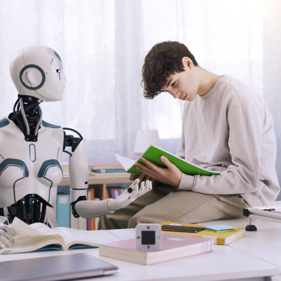 Ein junger Mann sitzt in einem modernen Lernumfeld neben einem humanoiden Roboter. Beide betrachten gemeinsam ein Buch – symbolisch für KI als Lernpartner.
