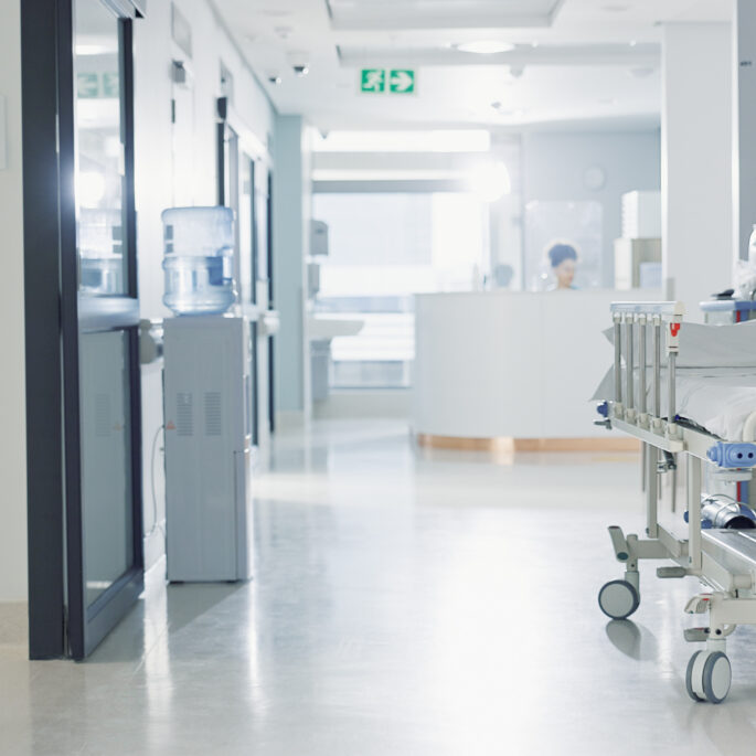 Moderner Krankenhausflur mit Patientenbett und medizinischer Infrastruktur in einer Klinik.