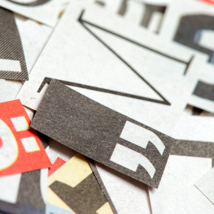 Ausschnitt von ausgeschnittenen Buchstaben und Satzzeichen auf Papier, die Typografie symbolisieren