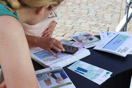 Seniorin wird am Stand des Digitalen Engels zu ihrem Smartphone geschult