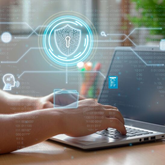 Person arbeitet an einem Laptop mit eingeblendeten Symbolen für Cybersicherheit, darunter ein Schild mit Schloss, Cloud, WLAN und Benutzer-Icons